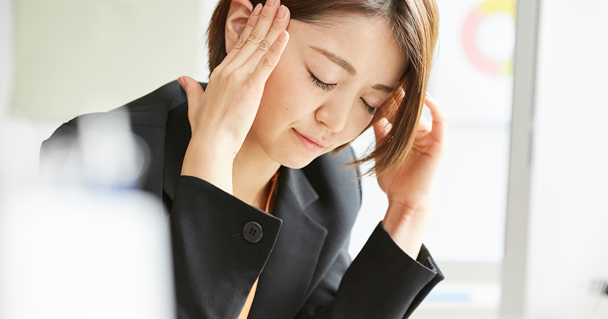 頭を押さえる女性の画像