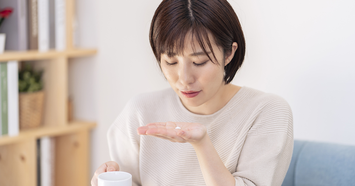 薬を飲もうとしている女性の画像
